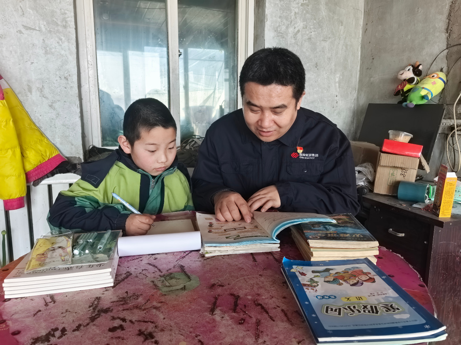 图为党员自愿者正在为留守儿童解说习题